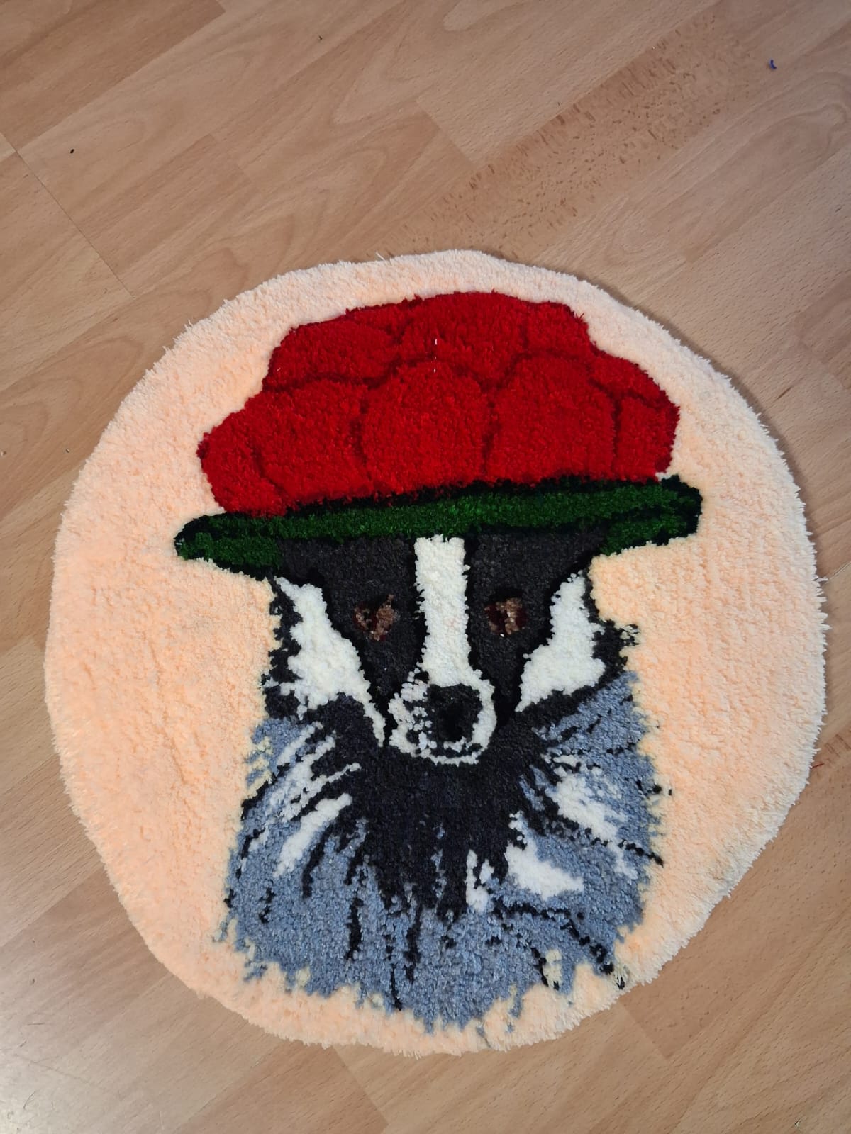 Dachs mit roter Mütze als rundes Tufting-Projekt im 45 × 45 cm Format