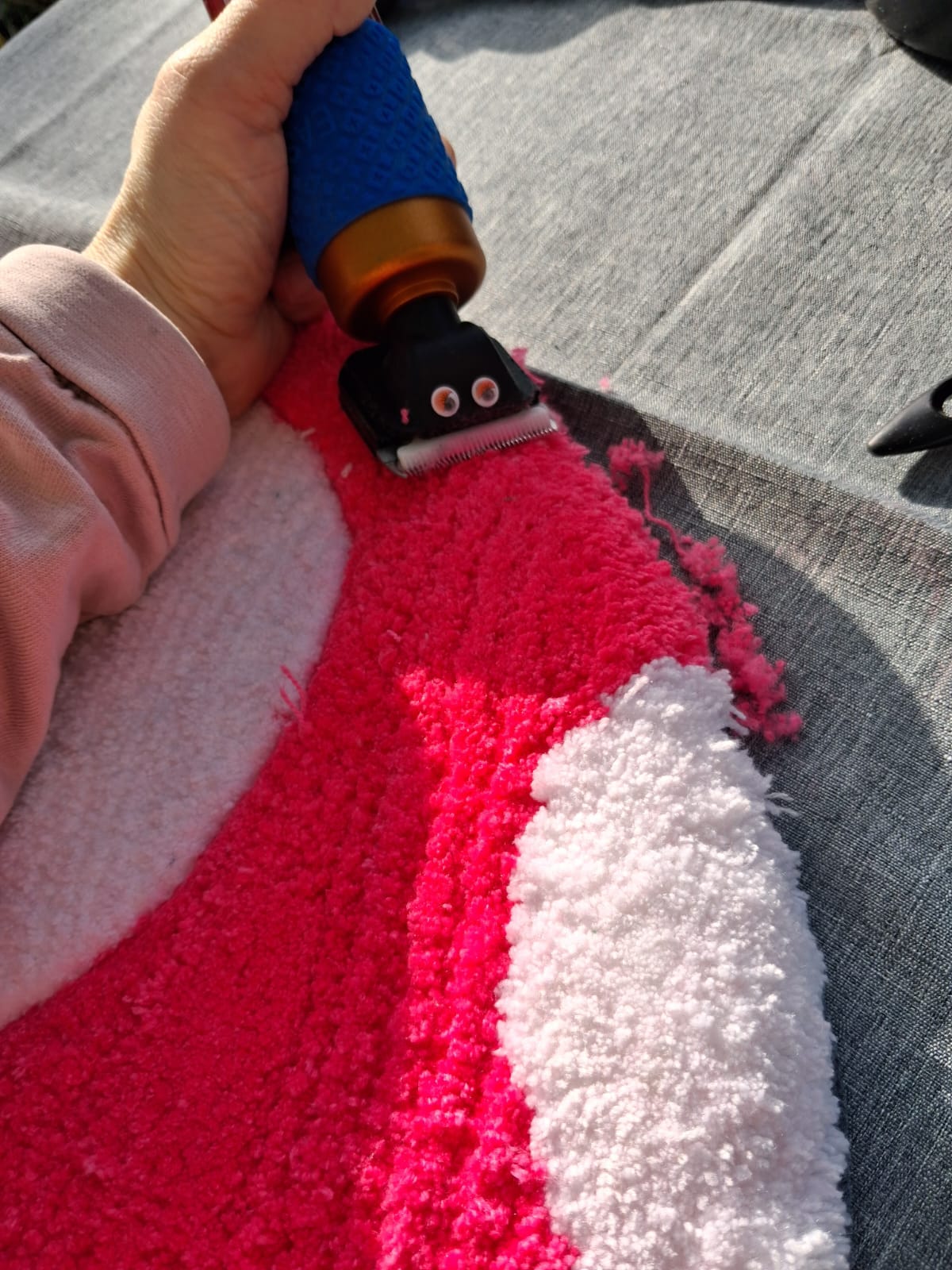 Nahaufnahme: Tufting-Teppich wird mit einem Trimmer professionell nachbearbeitet